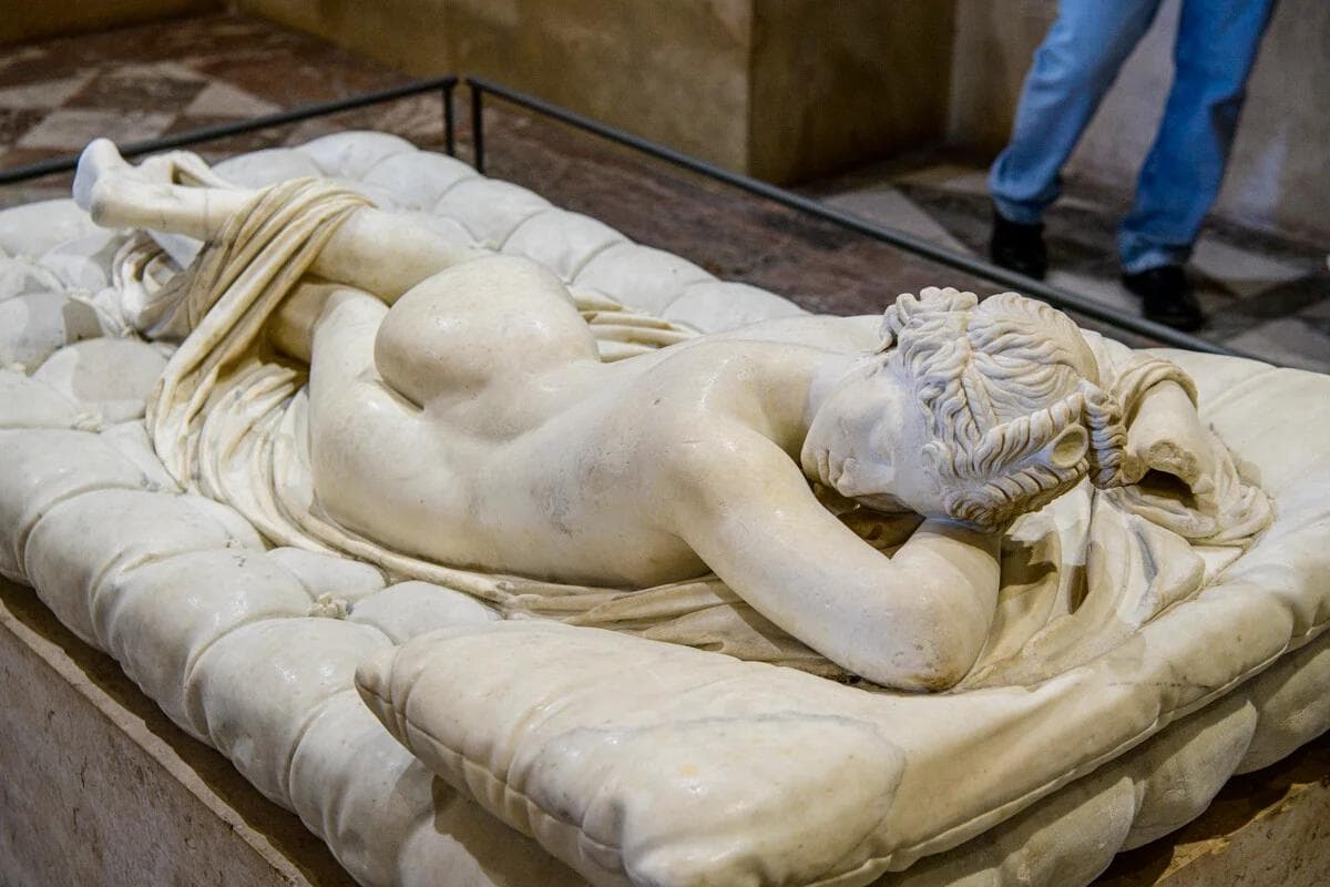 The serene face of the Hermaphrodite Endormi at the Louvre Museum in Paris, showing the braided hair and peaceful expression.
