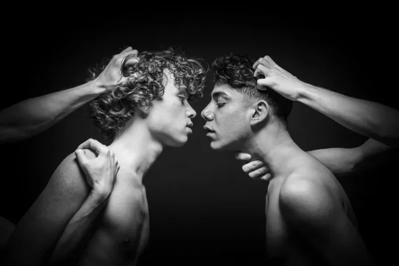 Black and white fine art photography titled Restraint 3 showing two men controlled by external hands in a dark space.